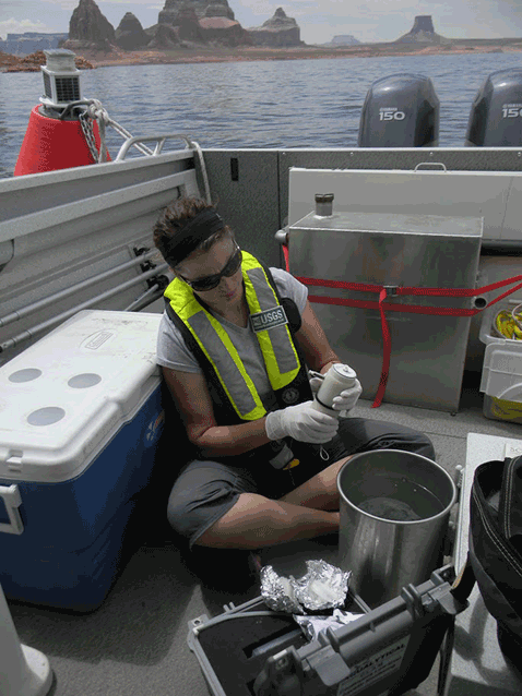 Woman sits in a boat with scientific equipment