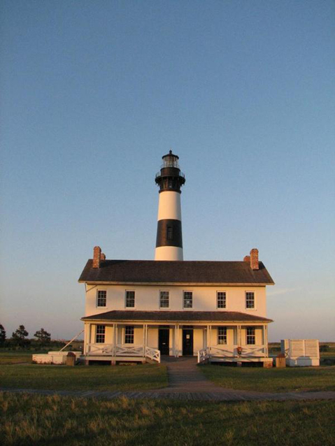 Present-day image of Bodie Island Light Station at sunset, showing tower and quarters