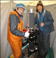 two researchers pose with gravimeter