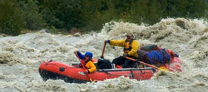 whitewater raft and two people on Alsek River