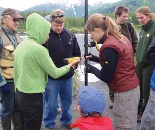 people standing around monitoring equipment at a campsite