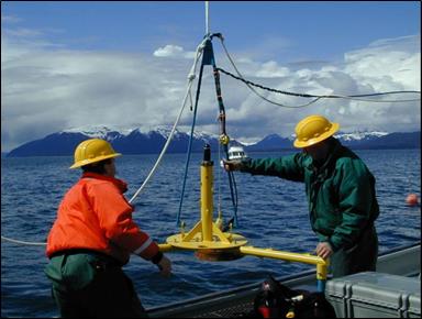 two scientists pull a hydrophone out of the water
