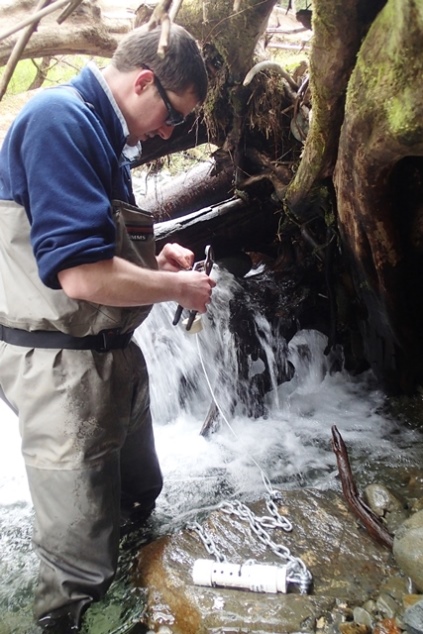 scientist installs temperature sensor to a stream scientist installs temperature sensor to a stream