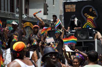 A crowd of people with rainbow flags and a sign that says A crowd of people with rainbow flags and a sign that says