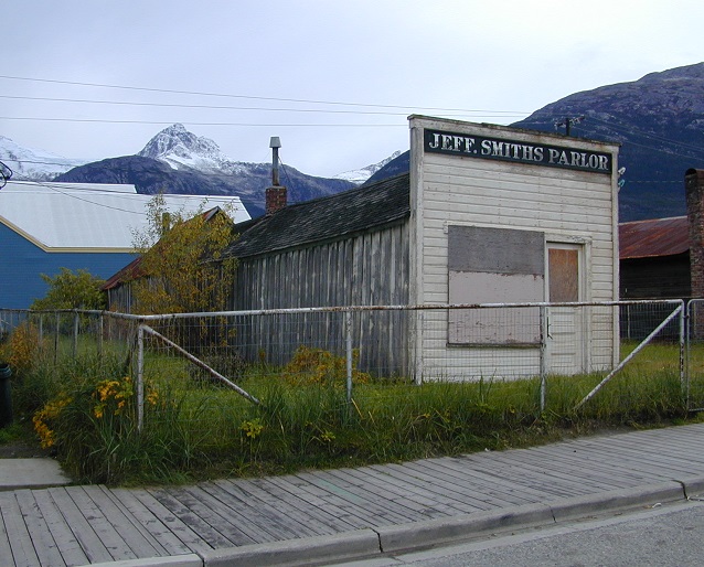 A white building in front of a snow-covered mountain
