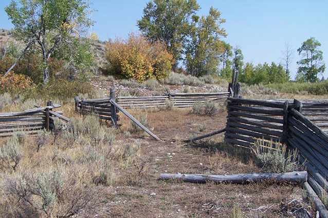 Wooden corral fence in a landscape of low vegetation