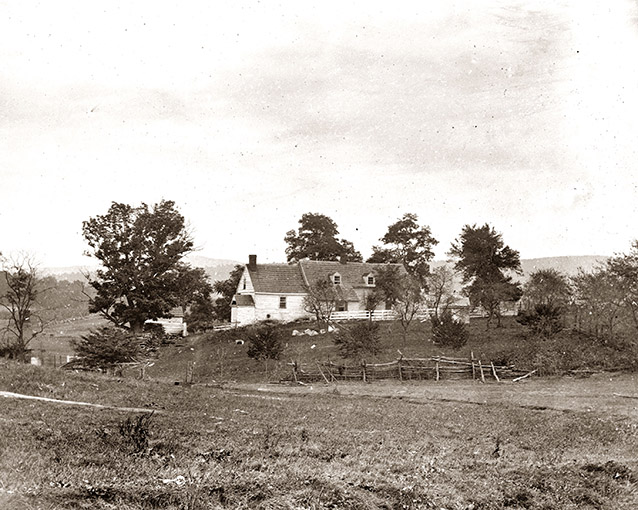 Historic images of a farmhouse and landscape, with several trees and a marshy area to the left.