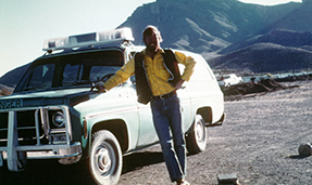 Historic photo of Galen besides a truck from 1982.