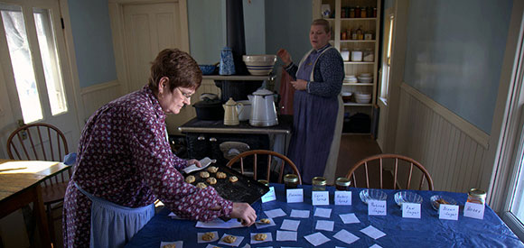 Two women baking cookies and preparing for an event.