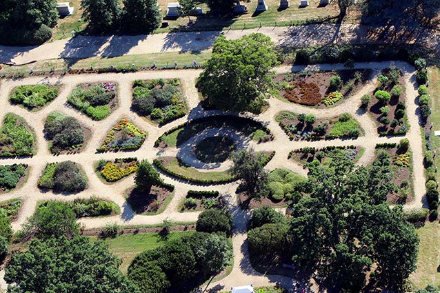 Aerial view of a formal garden, with symmetrical paths dividing garden beds. Aerial view of a formal garden, with symmetrical paths dividing garden beds.