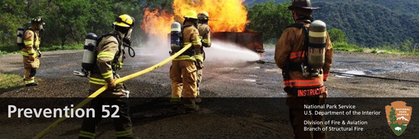 structural firefighters training with live fire and large fire hose