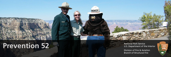Smokey bear and park visitors pose for a photo