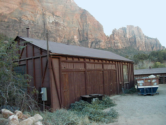 Steep cliffs beyond a rectangular brown garage Steep cliffs beyond a rectangular brown garage