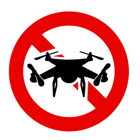 Drawing of unmanned aircraft with slash through it denoting ban.
