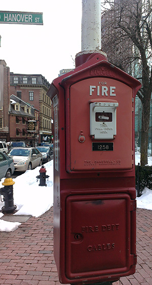 red historic fire alarm box outside on a telephone pole.