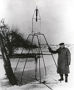 Dr. Robert H. Goddard and a liquid oxygen-gasoline rocket in the frame from which it was fired