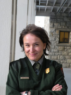 A smiling woman in NPS uniform with crossed arms 