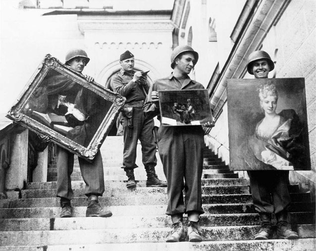 Historic photo of four men in military uniform on stairs, holding paintings