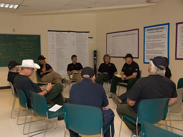 Incident management team members seated in a circle for a meeting Incident management team members seated in a circle for a meeting