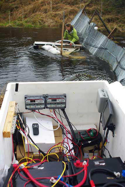 a woman in waist-deep water next to a weird adjusting scientific equipment