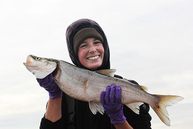 a woman holding a large fish with two hands