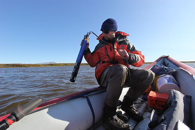 person sitting in the back of a raft using a scientific instrument in the water person sitting in the back of a raft using a scientific instrument in the water