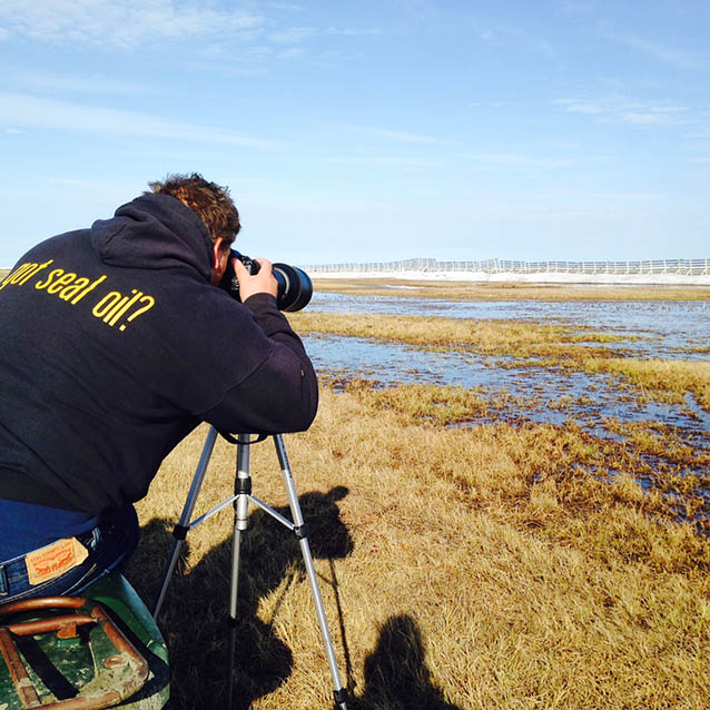 a person taking a photo of a marsh