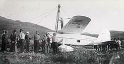 Wiley Post standing on his airplane the Winnie Mae, 