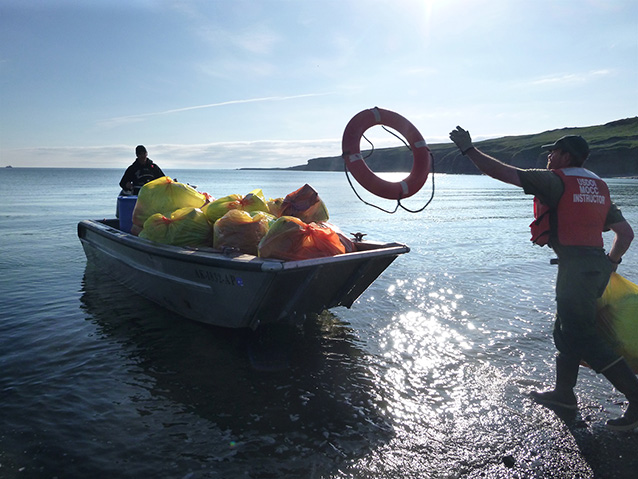 person tossing a life ring into a small boat