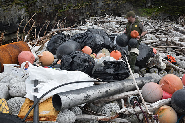 bags of trash on a rocky beach