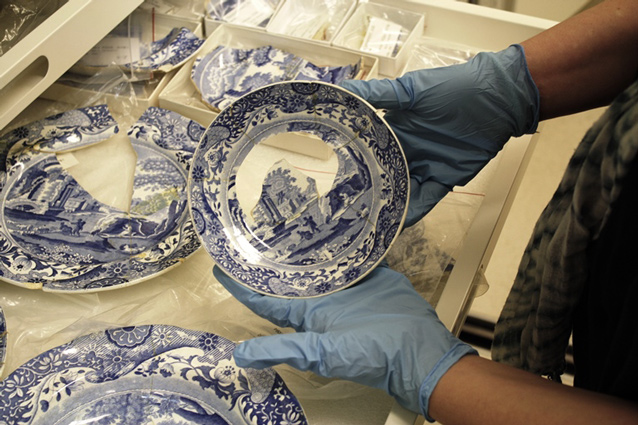 Curator wearing blue gloves and holding Spode saucer. Curator wearing blue gloves and holding Spode saucer.