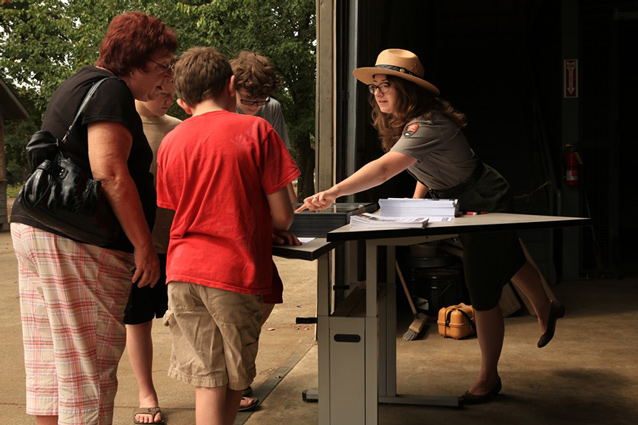 Curator Meagan Huff points out artifacts to visitors