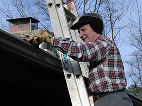 person cleaning house gutters