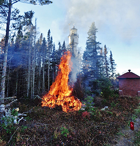 Pile burn near base of lighthouse.