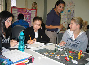 Several women sit around a table engaged in discussion.