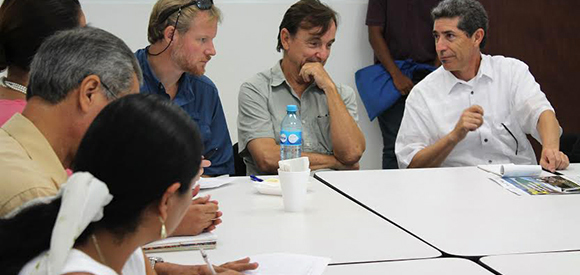 Scientists and managers confer around a table.