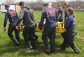 Firefighters carry a litter.