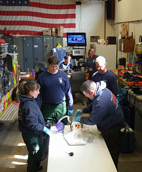 Firefighters use a lifesaving device during practice.