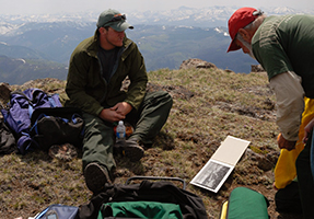 team examining an old photograph before attempting to recapture the image