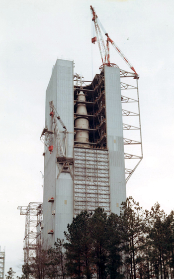 A large white rocket inside of a light blue tall building