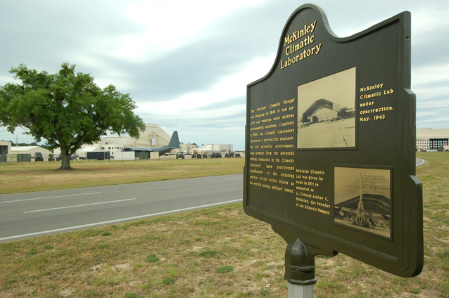 Large buildings in the background on the left and a bronze plaque in the foreground on right