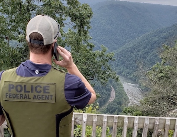 A Special Agent listens to a caller on a mobile phone.