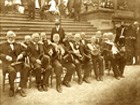 Gray-haired veterans sitting for a formal photograph 