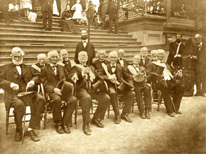 Gray-haired veterans sitting for a formal photograph 