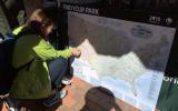 Visitor pinning her favorite park on a map of national parks nationwide