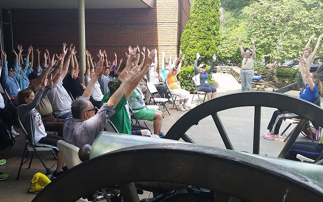 Senior citizens participate in a guided yoga program.
