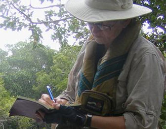 woman writing outdoors in a journal