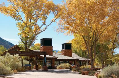 Zion Canyon Visitor Center sits among yellow cottonwood trees in the fall.
