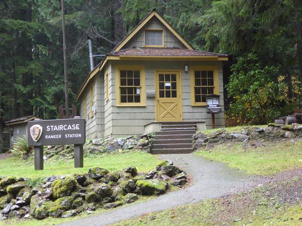 A small house with a sign outside that reads "Staircase Ranger Station."