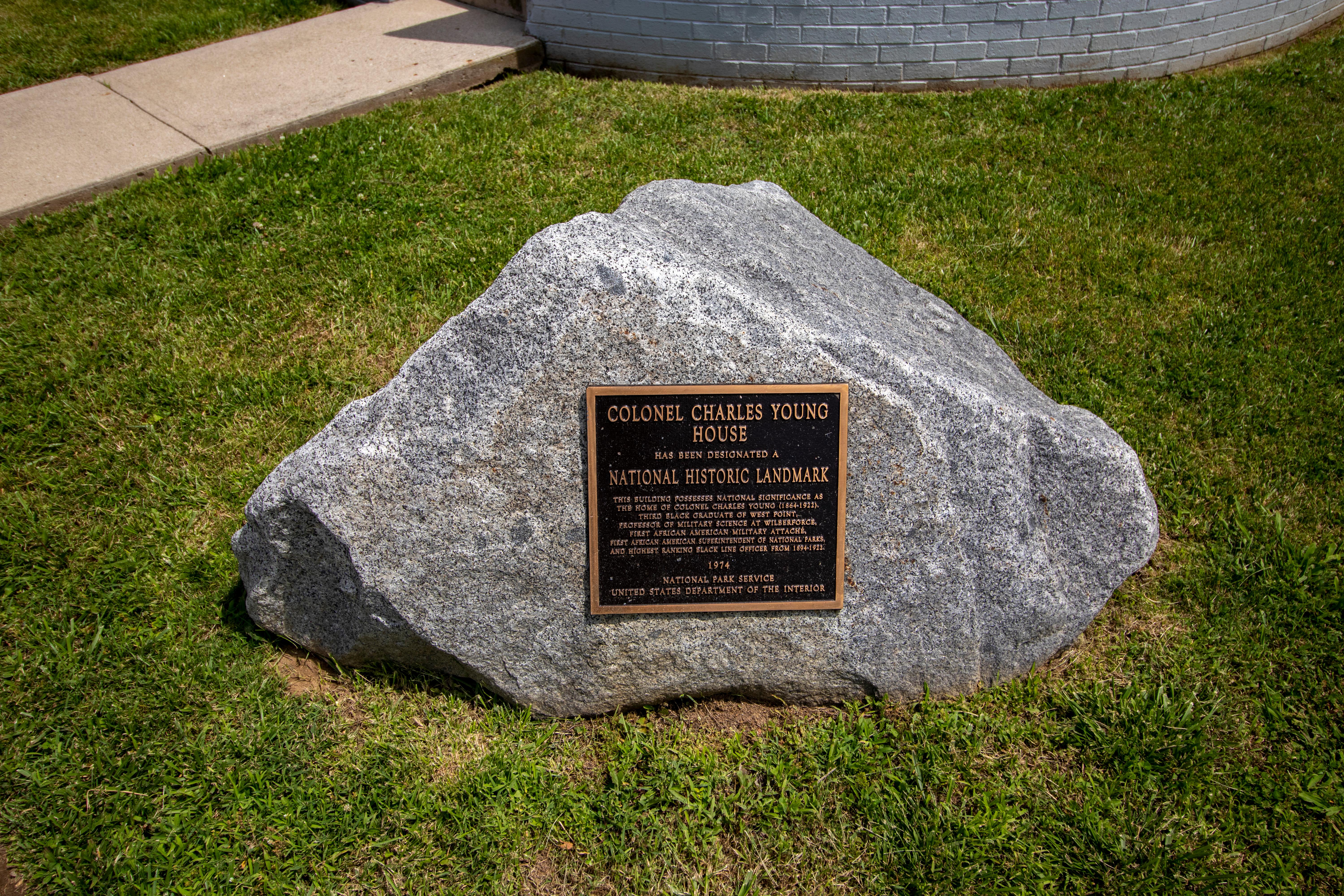 A large gray stone boulder with a bronze plaque on it indicating a national historical landmark
